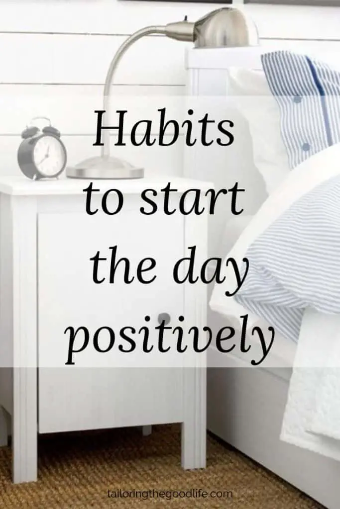 white nightstand with lamp and clock next to bed - start the day with positivity