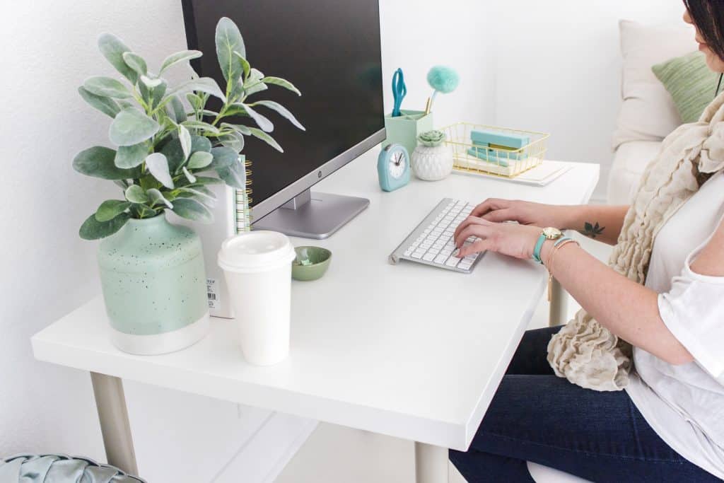 Lady sitting at her desk behind her computer - Productivity Journal