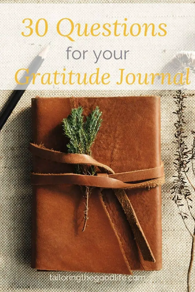 leather journal on canvas back ground with a pencil and some twigs ready for gratitude journal prompts