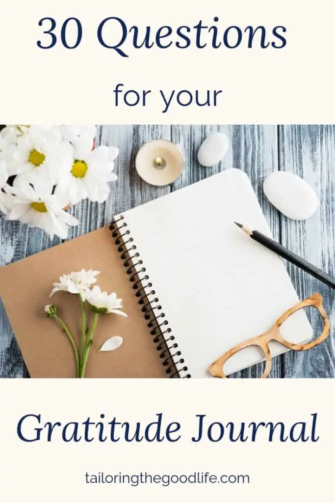 open notebook on a white-washed table with flowers and a pencil ready  for gratitude journal prompts