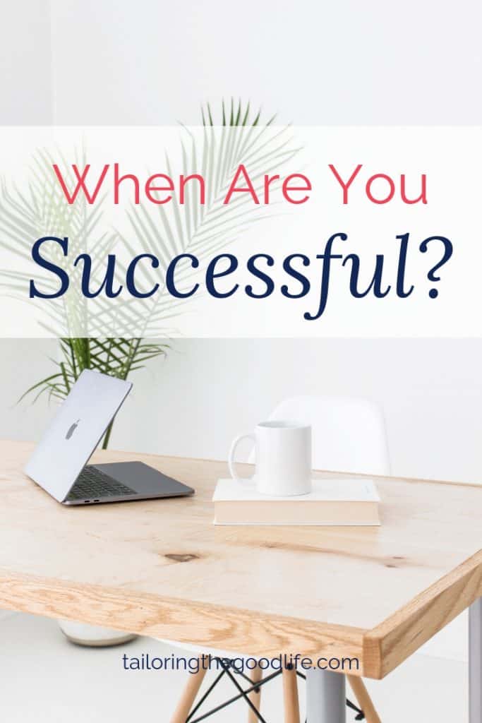 Book, mug, and laptop on deck with white chair and plant in corner